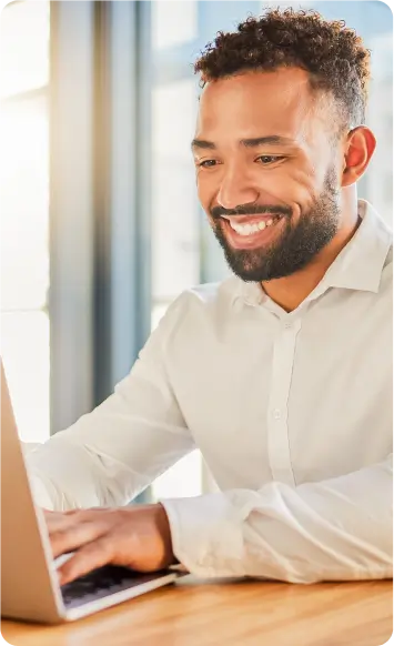 Melhor Software Odontológico. Homem Sorrindo Usando Laptop