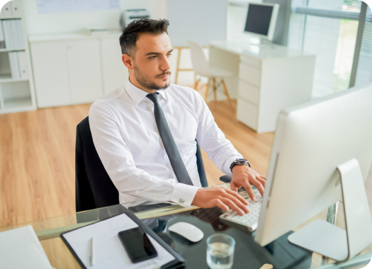 Homem de social trabalhando em seu computador.