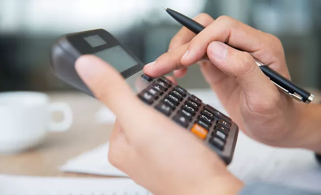 Obrigações tributárias. Gestor calculando os tributos da sua clínica